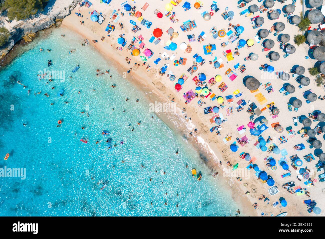 Luftaufnahme des Sandstrands mit bunten Sonnenschirmen Stockfoto