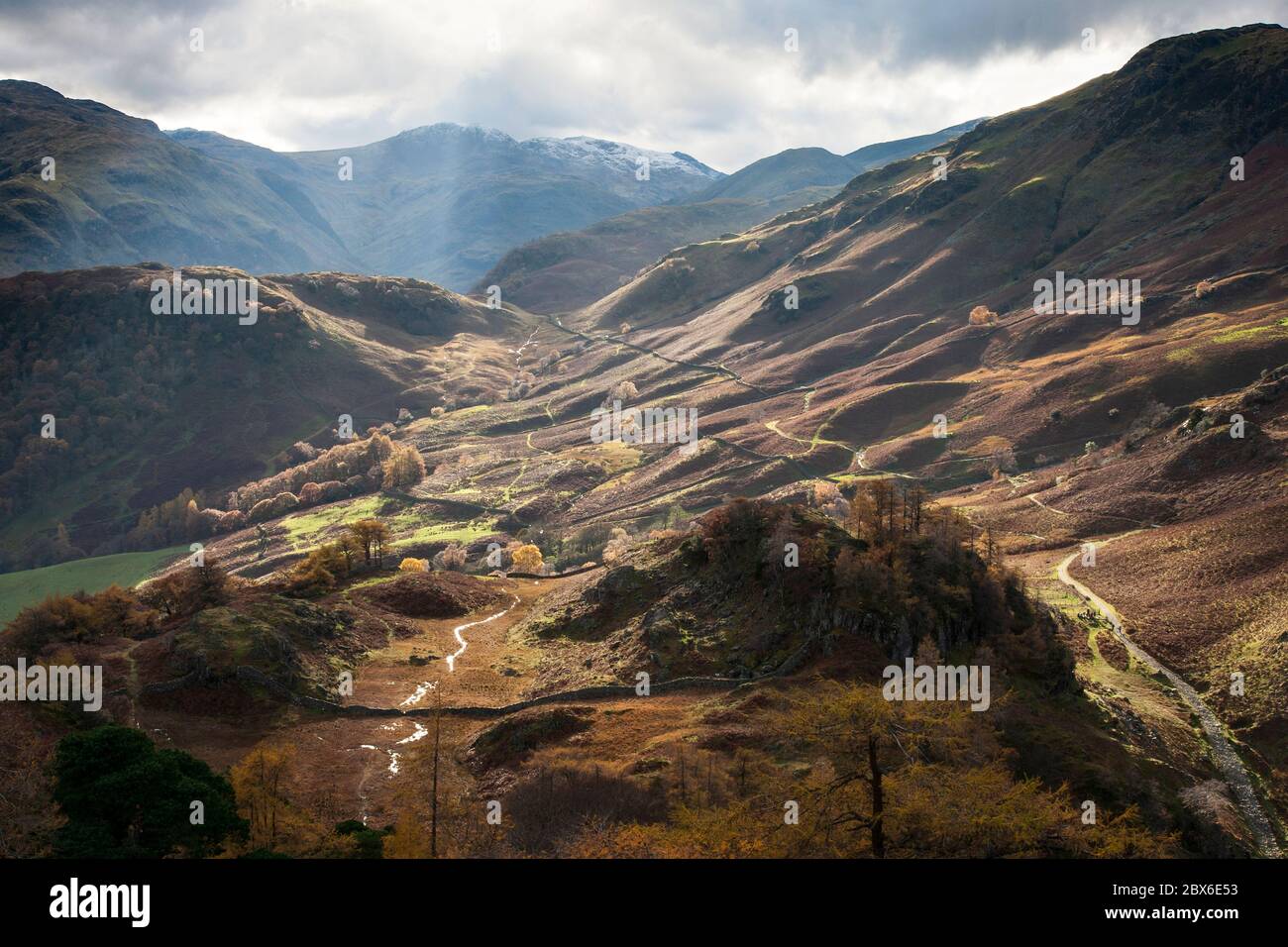 Herbststrahlen des Sonnenlichts, die durch Wolken strömen und das untere Borrowdale Tal erleuchten, von Castle Crag, Lake District, Cumbria, England aus gesehen Stockfoto