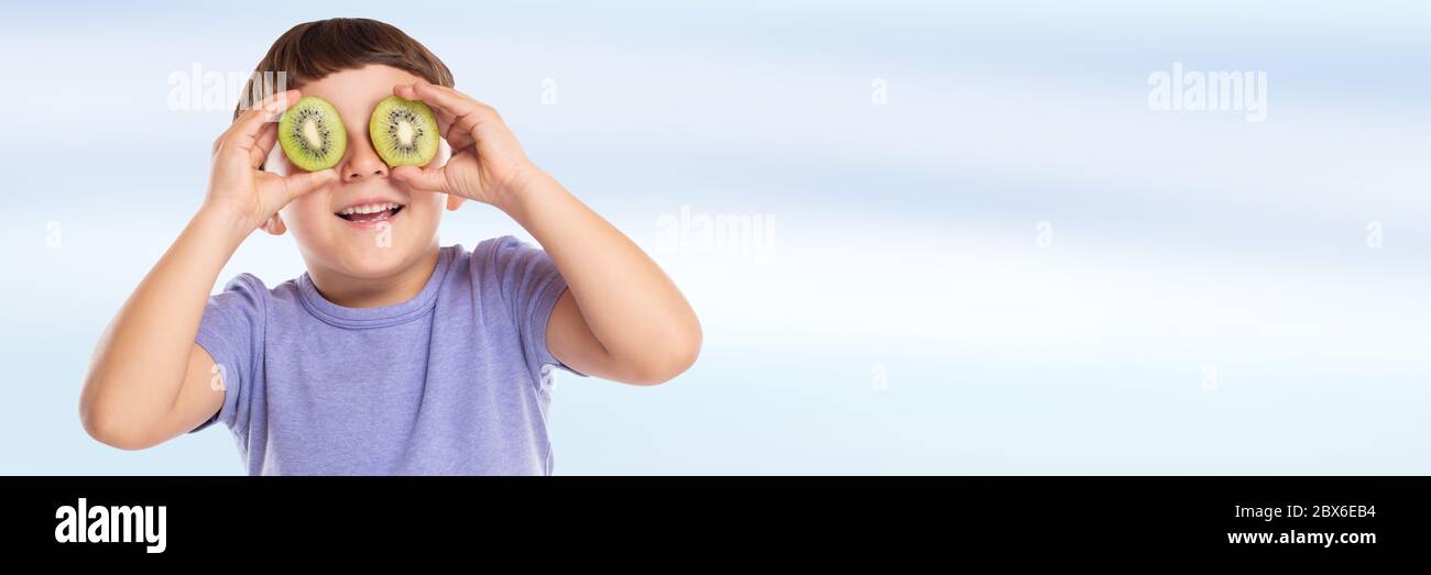 Kleiner Junge Kind mit Kiwi Obst Spaß Banner Copyspace kopieren Raum glücklich Glück gesund essen Kind Stockfoto