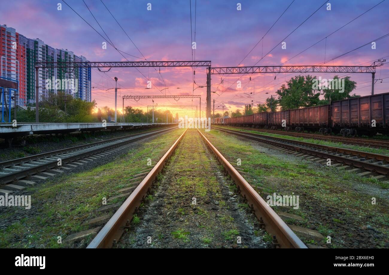 Bahnhof mit Güterzügen bei buntem Sonnenuntergang Stockfoto
