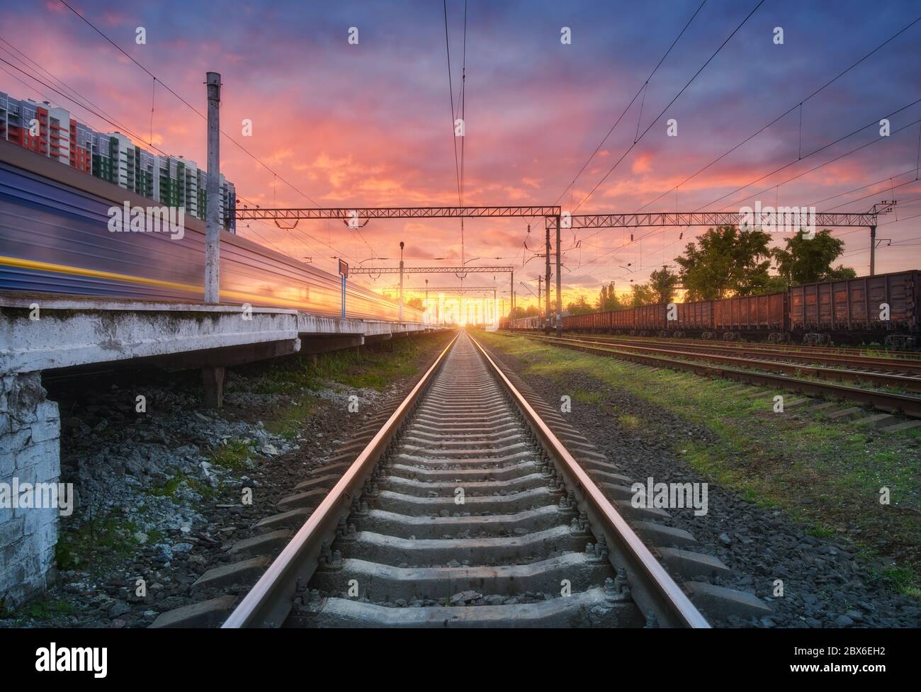Bahnhof mit Güterzügen bei buntem Sonnenuntergang Stockfoto