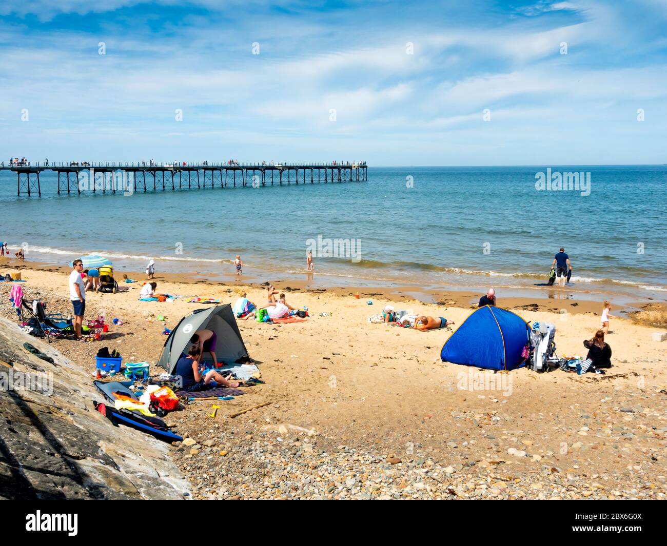 Saltburn Beach und Pier am Tag nach der Verringerung der Lockdown-Versorgung während der Coronavirus-Pandemie in 2020 Familiengruppen können mit f treffen Stockfoto