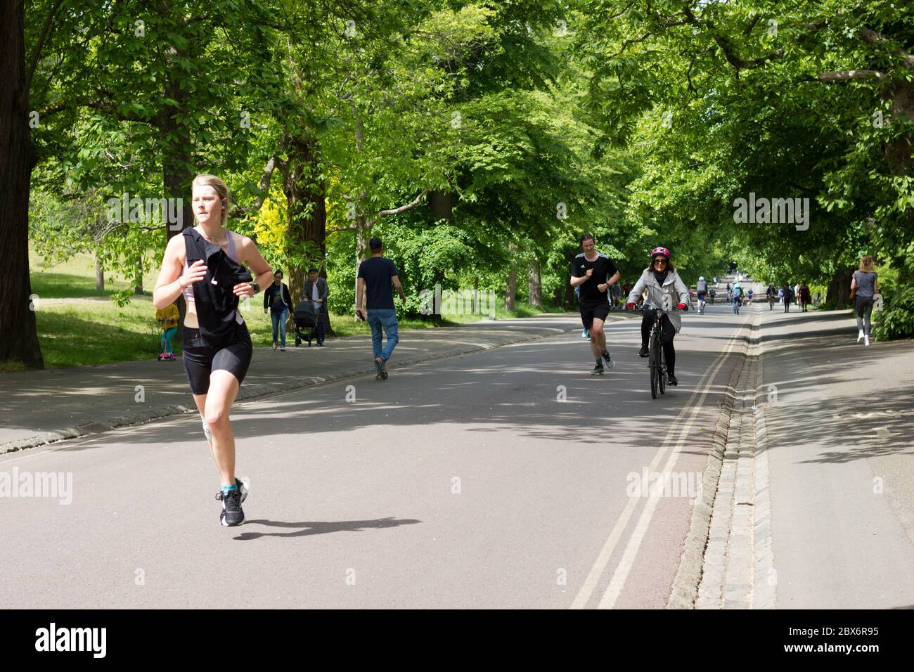 Frauen Läufer, Jogger und Radfahrer trainieren in Greenwich Park, Kampf covid-19 Pandemie im Sommer, London, England Stockfoto