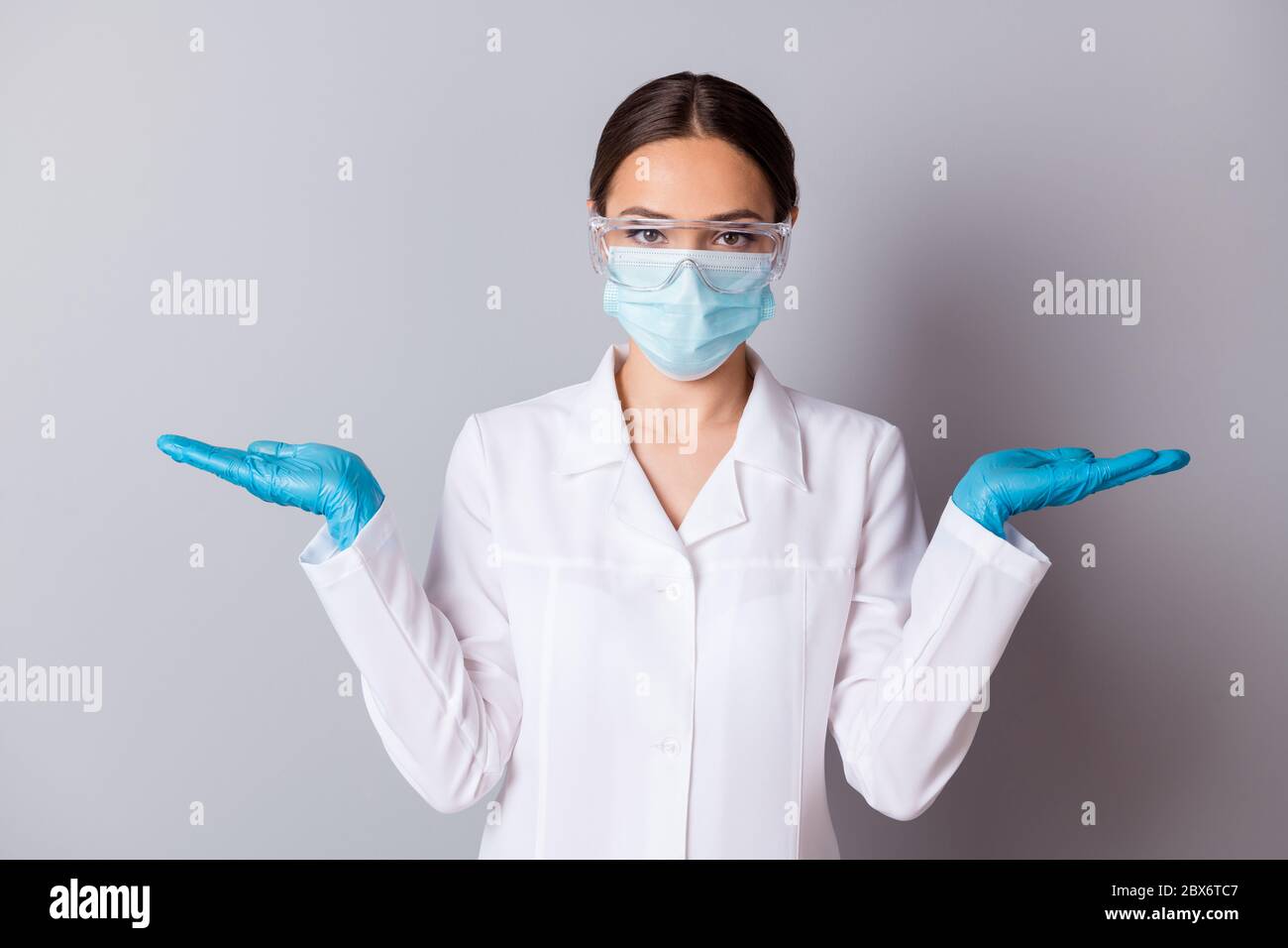 Foto von Virologe Doc Dame erfahrene professionelle halten zwei offene Handflächen Untersuchung Impfstoff Projekt Vergleich tragen Handschuhe Brille Gesichtsmaske Uniform Stockfoto