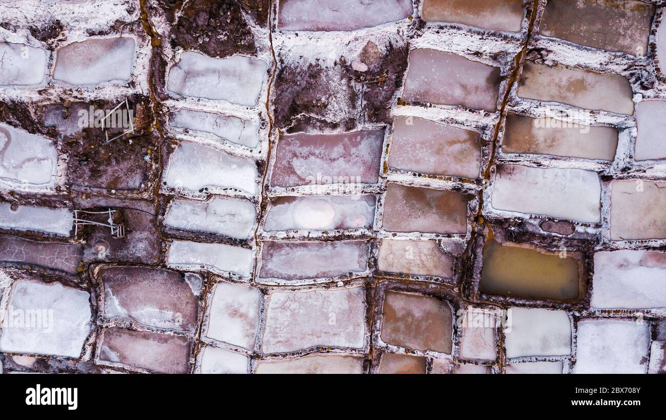 Luftaufnahme von Salzverdunstungsteichen in einer Salzmine in Maras, Peru. Verschiedene Formen und Farben von Teichen erzeugen abstrakte Muster und Formen. Stockfoto