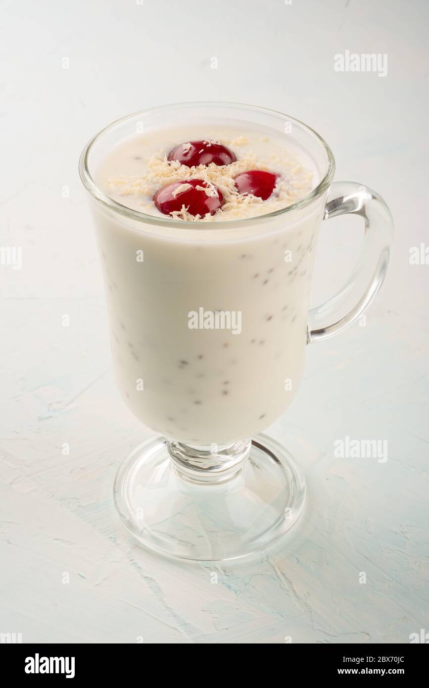 Chia Joghurt Pudding mit Kokosflocken und Kirschenbeeren. Gesunde Ernährung, um Kraft und Gewicht zu reduzieren. Chia und Joghurtpudding im Glas Stockfoto