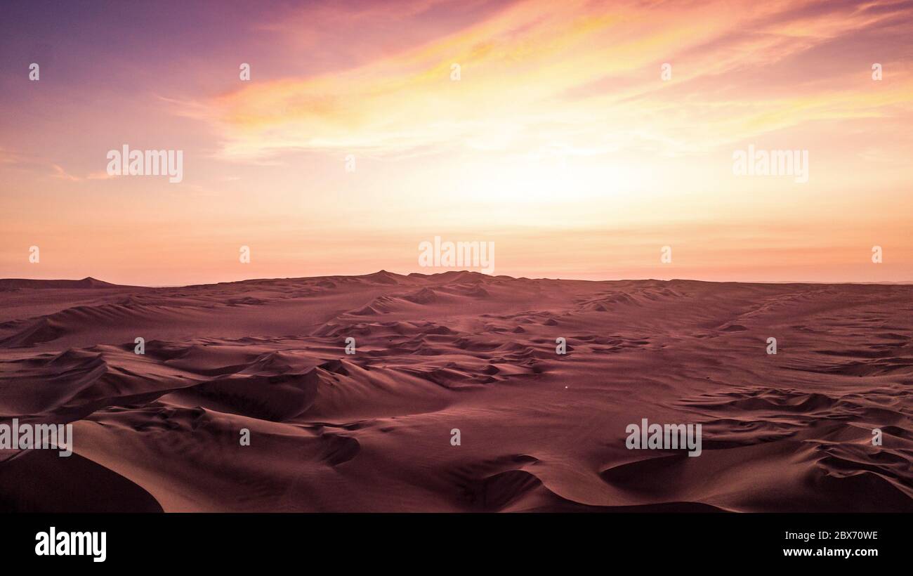 Marsian Landschaftsansicht der Wüste mit Sanddünen während des orange - lila Sonnenuntergangs in Peru. Stockfoto