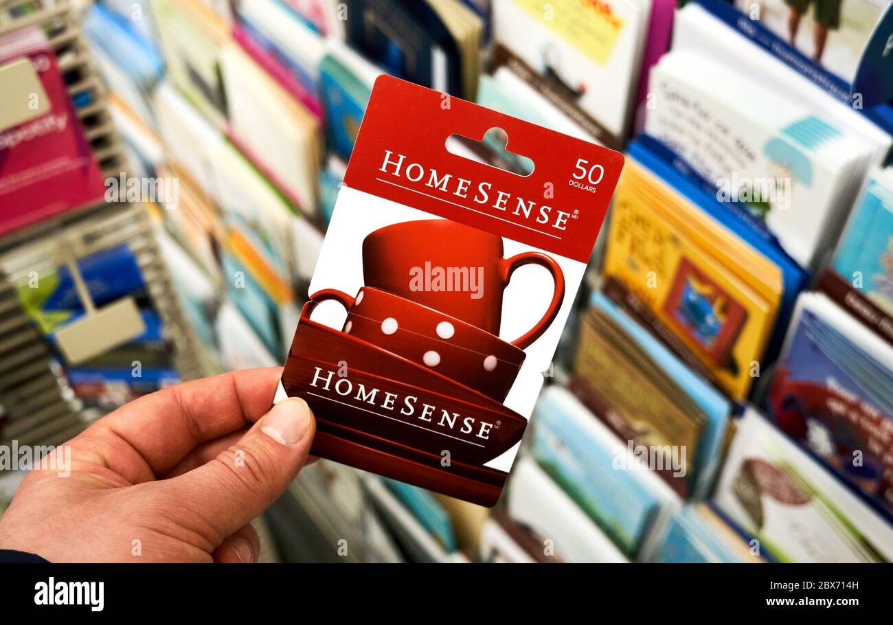 Montreal, Kanada - 03. Mai 2020: HomeSense Geschenkkarte in einer Hand über einem Ständer mit Geschenkkarten. HomeSense ist eine kanadische Kette von preisgünstigen Wohneinrichtungen Stockfoto