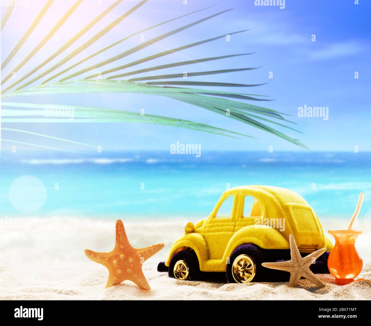 Lviv, Ukraine-04. Juni 2020: Sommerstrand mit Seesternen, kleiner Spielzeugauto, Cocktail im weißen Sand und tropischen Palmenblättern. Stockfoto