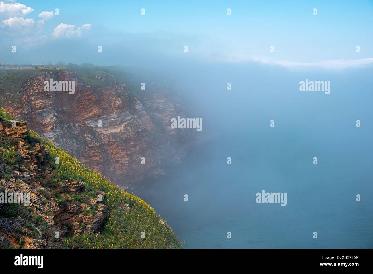 Felsige Küste und Nebel über dem Meerwasser. Stockfoto