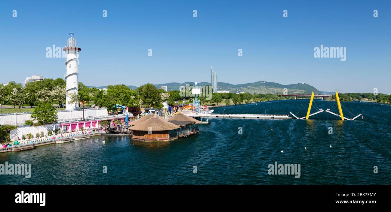 Der Leuchtturm auf der Donauinsel mit der Ponte Cagrana Brücke im Frühjahr. Wien, Österreich. Stockfoto