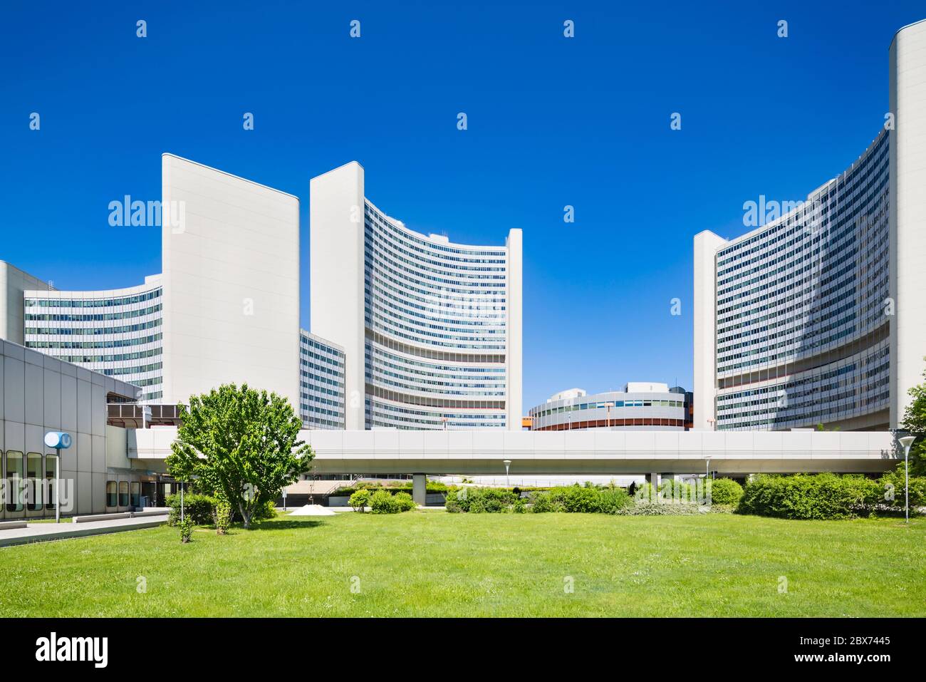 Das Vienna International Center oder UNO City mit grüner Wiese und blauem Himmel im Sommer. Stockfoto