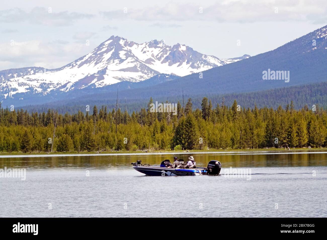 Ein Fischerboot fährt am Crane Prairie Lake in den zentralen Cascade Mountains von Oregon entlang. Broken Top Peak befindet sich im Hintergrund. Stockfoto