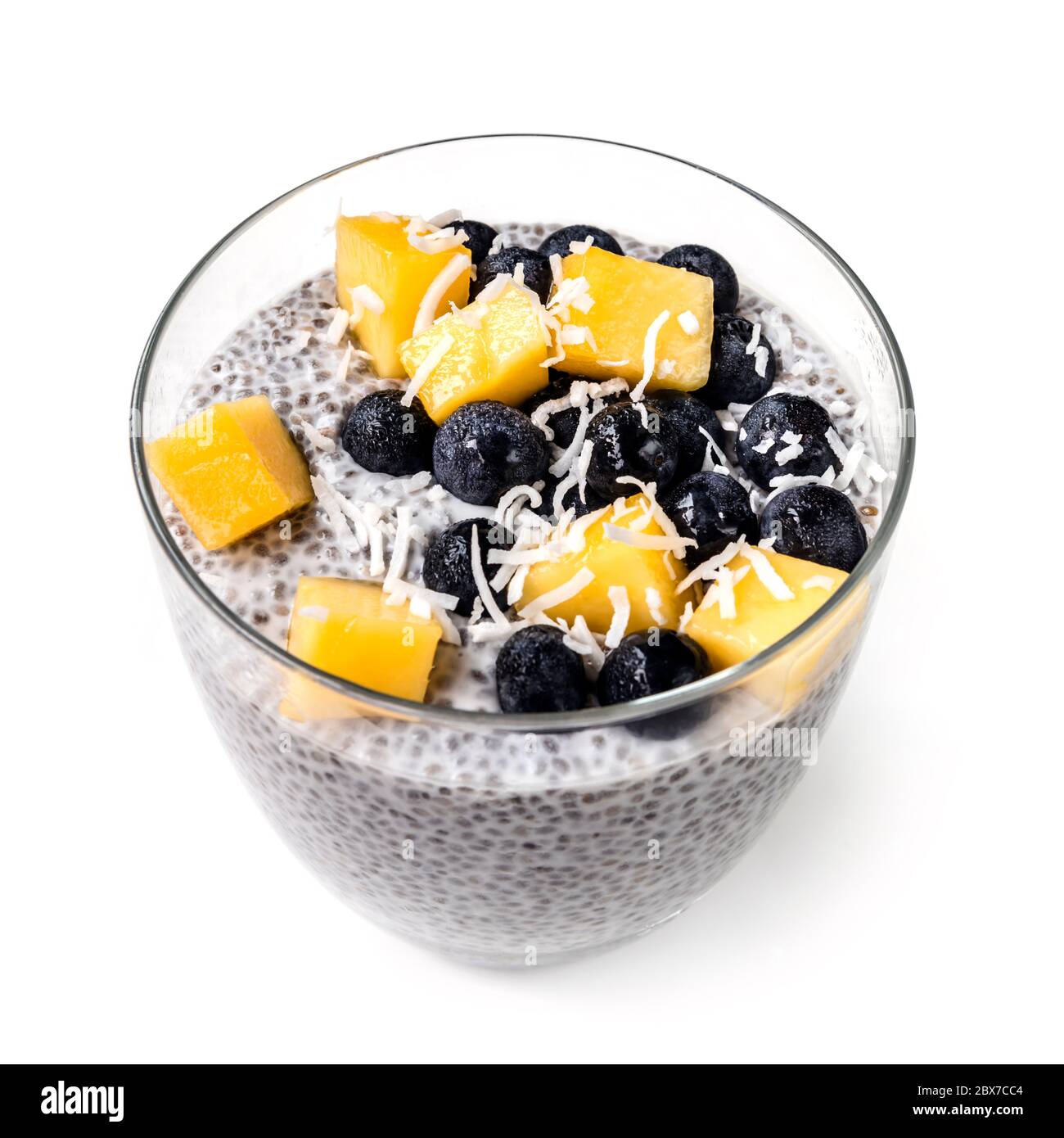 Chia Pudding isoliert in Glas mit Heidelbeeren, Mango und Kokosraspeln. Veganes Superfood. Stockfoto