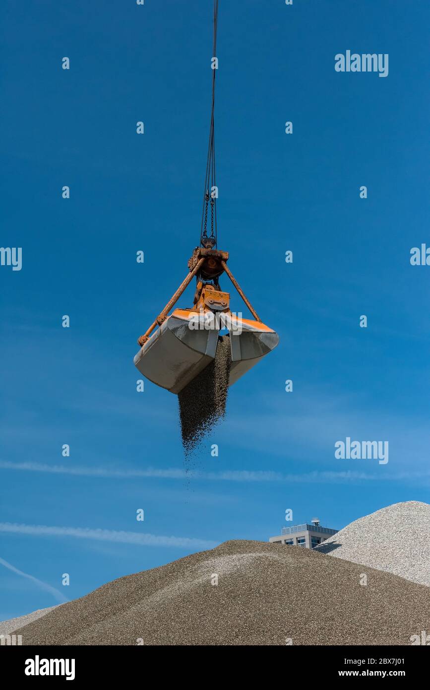 Greifkran füllt Sand von einem Hügel zum anderen Stockfoto