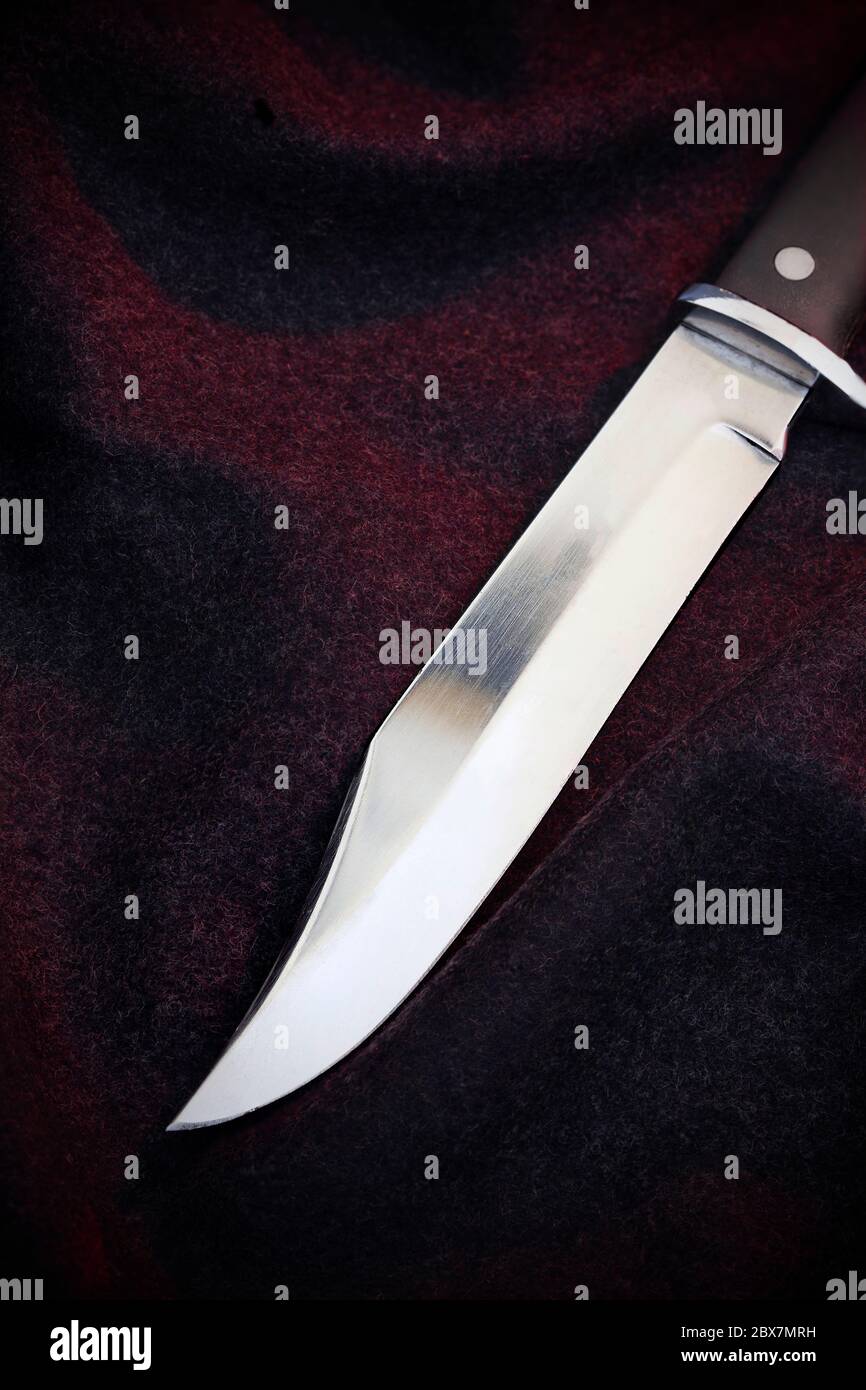 Langes Messer mit blinkender Klinge auf dunklem Hintergrund mit Kopierraum Stockfoto