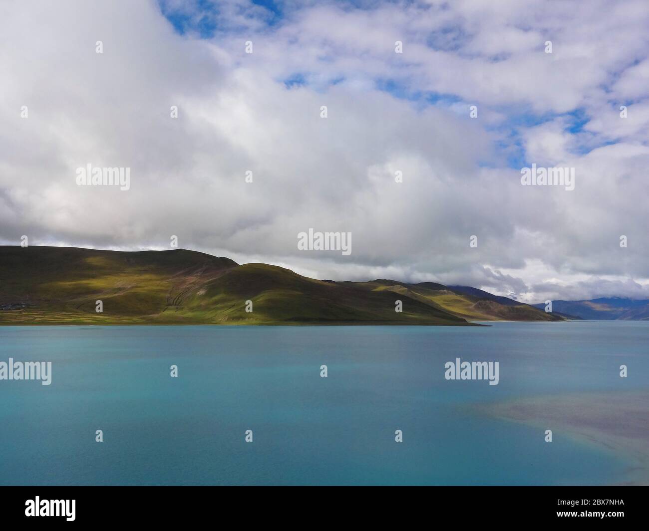 Weiße Wolken bedecken Berg und See in Tibet Stockfoto