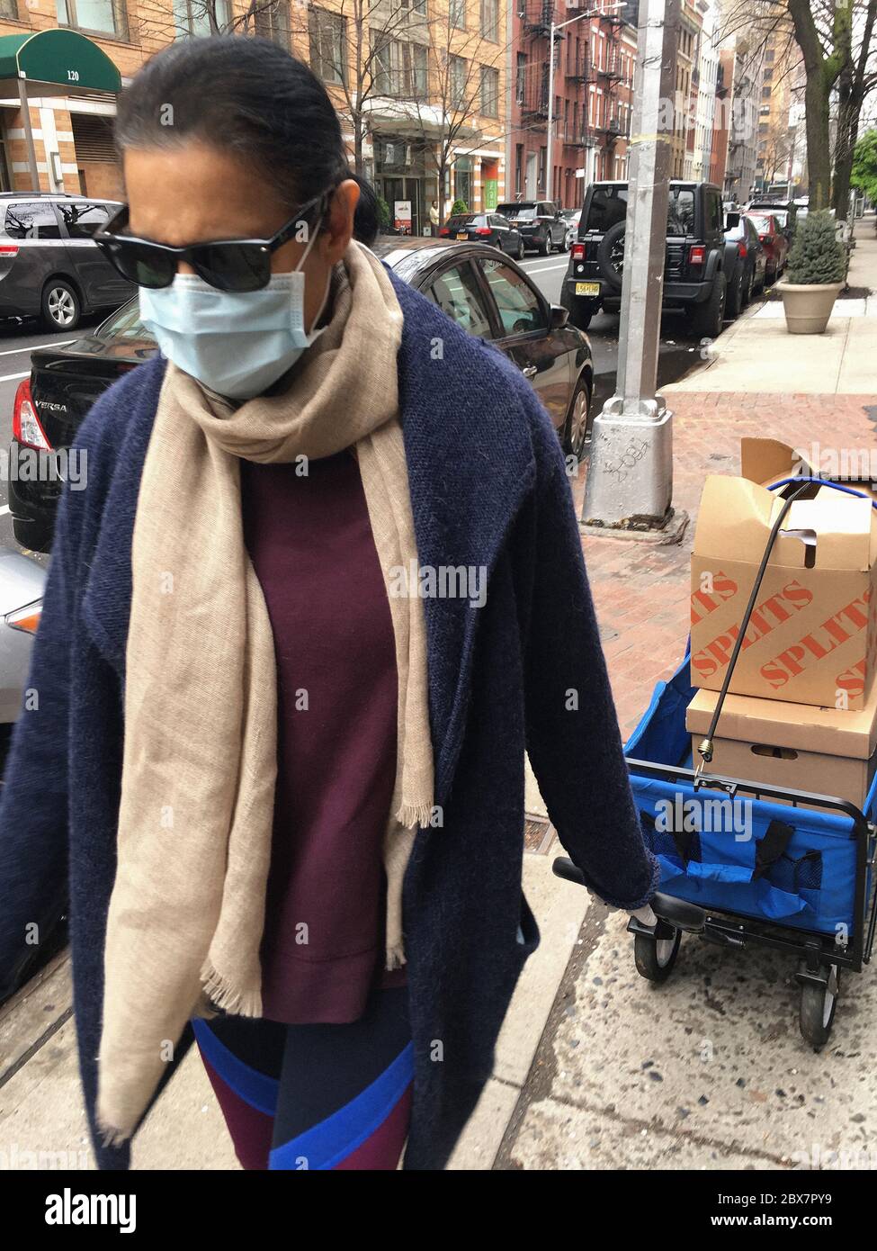 Weibliche Caterer mit Schutzmaske zieht Food Cart, New York City, New York, USA, April 2020 Stockfoto