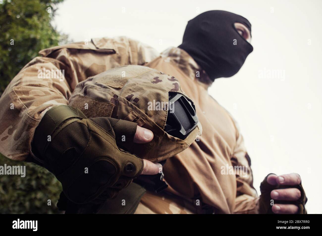 Militärsoldat in Uniform und taktische Handschuhe bereit für einen Kampf mit einem Tarnhelm Brustansicht. Stockfoto