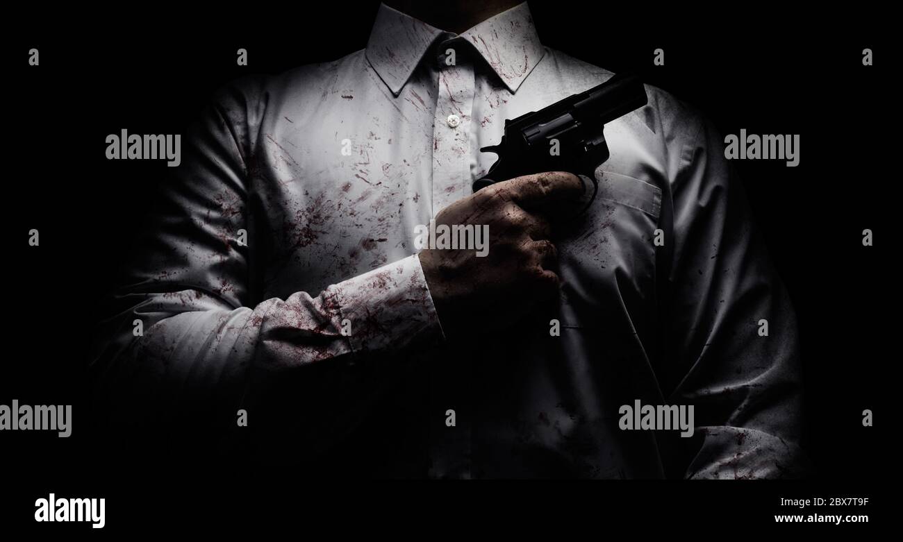 Horror gruseliges Foto eines Killers in weißem Hemd mit Blutspritzer und posiert mit schwarzer Waffe auf dunklem Hintergrund. Stockfoto