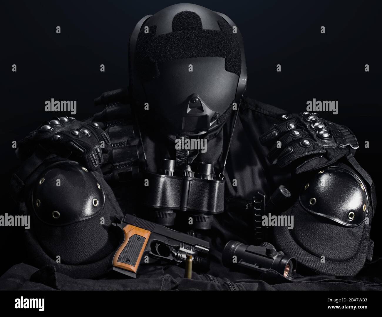 Schwarze taktische Waffe, Helm, Glasurte, Patronengürtel, Bandolier, Waffenhülle, Messer, Fernglas- und Knieschutz auf einem schwarzen Tisch. Stockfoto