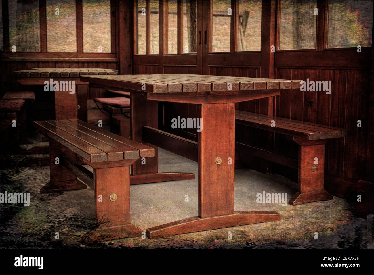 Tische und Bänke aus Massivholz in Blockhütte. Grunge-Stil Stockfoto