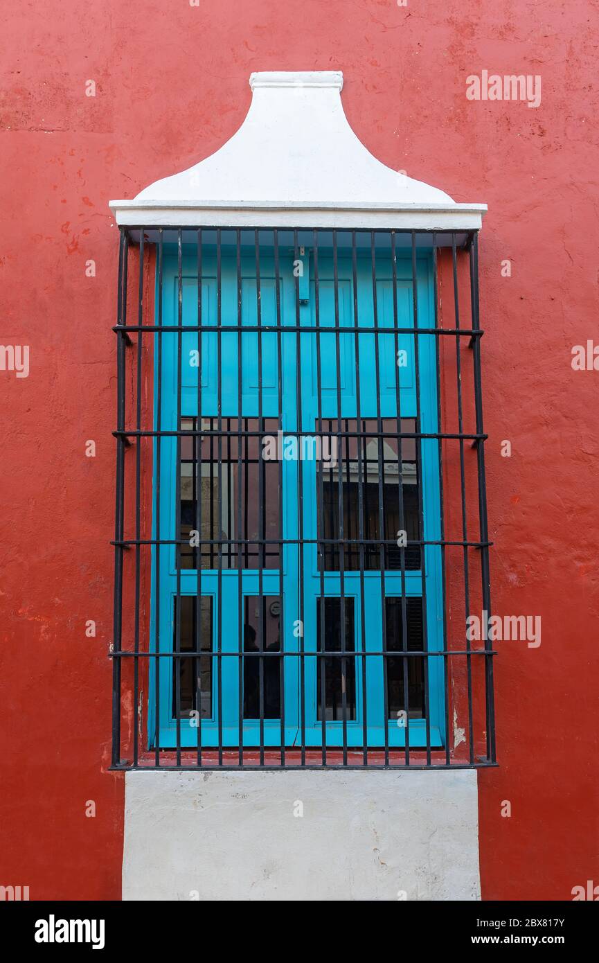 Rote Fassade mit türkisfarbenem Fenster im historischen Stadtzentrum von Campeche, Yucatan Peninsula, Mexiko. Stockfoto