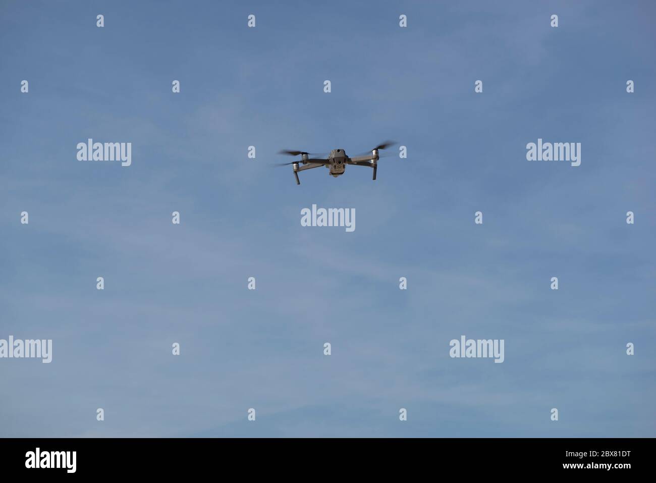 Drohne fliegt in blauem Himmel mit Wolken im Hintergrund. Drohne fliegt über dem Himmel in wolkig-blauem Himmel. Drohne Quad Copter mit hochauflösender digitaler Kamera Stockfoto