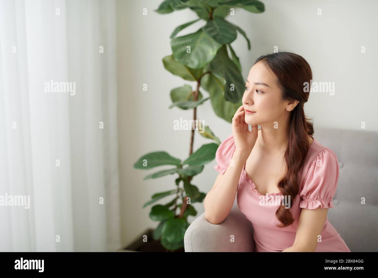 Porträt der jungen asiatischen Frau sitzt zu Hause. Stockfoto