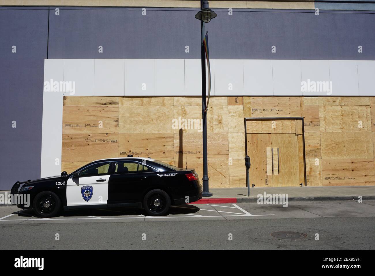 Geparktes Polizeiauto vor dem Apple Store, das nach den Unruhen von George Floyd verladen wurde. Bay Street Mall, Emeryville, Kalifornien, USA Stockfoto