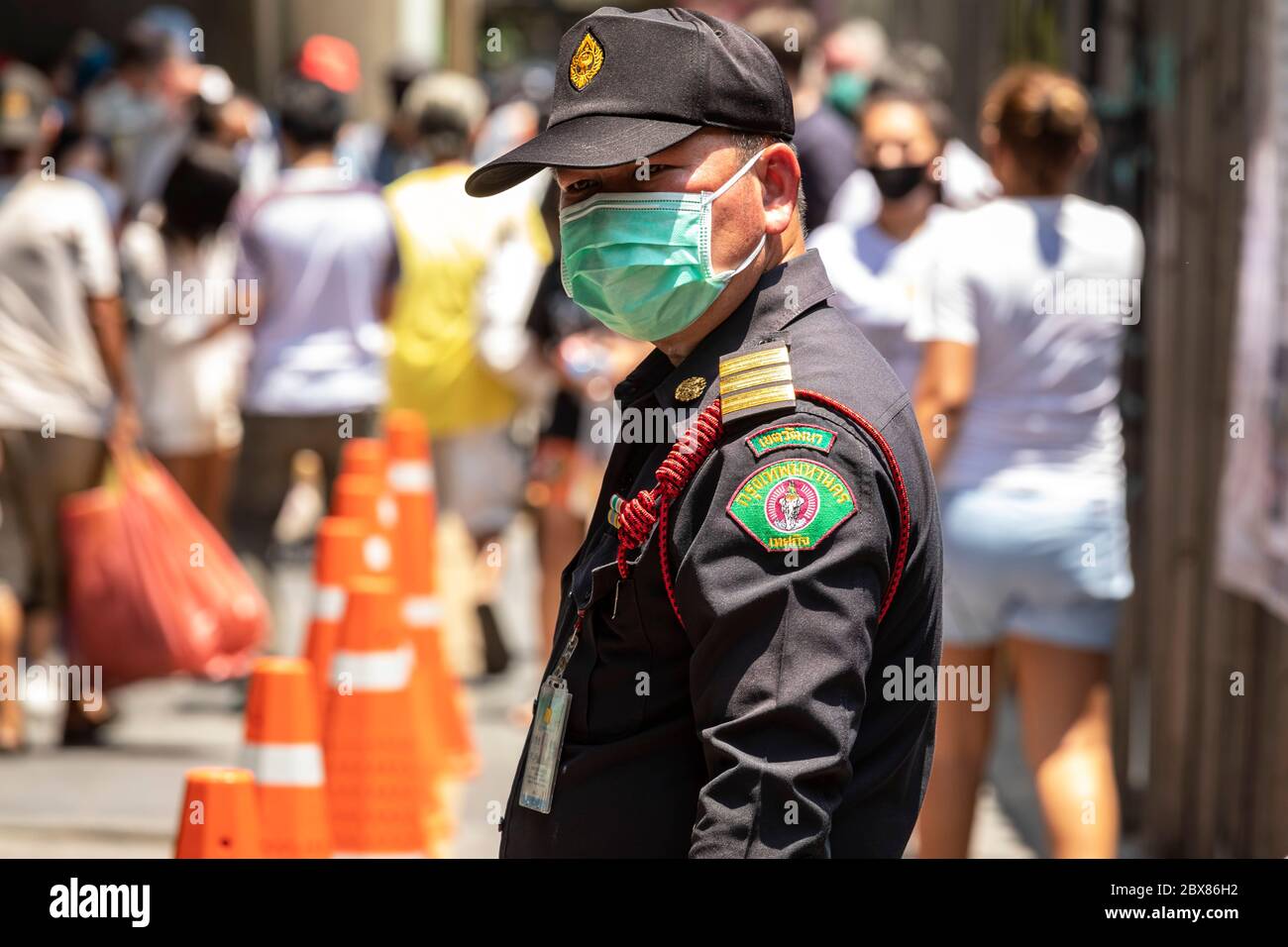 BMA Offizier mit Gesichtsmaske Kontrolle der freien Lebensmittelbank Verteilung während Covid Pandemie, Bangkok, Thailand Stockfoto