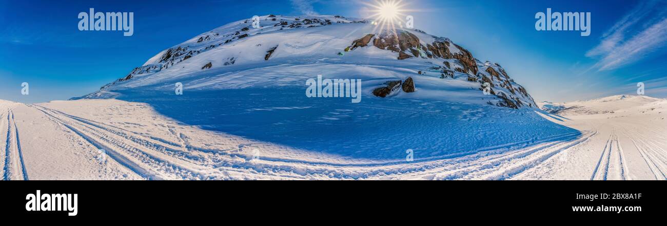 Panoramablick auf den Atoklinten Berg in Lappland, Nordschweden, Seitenansicht. Alle Schneemobile fahren hier, viele Wanderwege um. Helle Sonne scheint nur ein Stockfoto