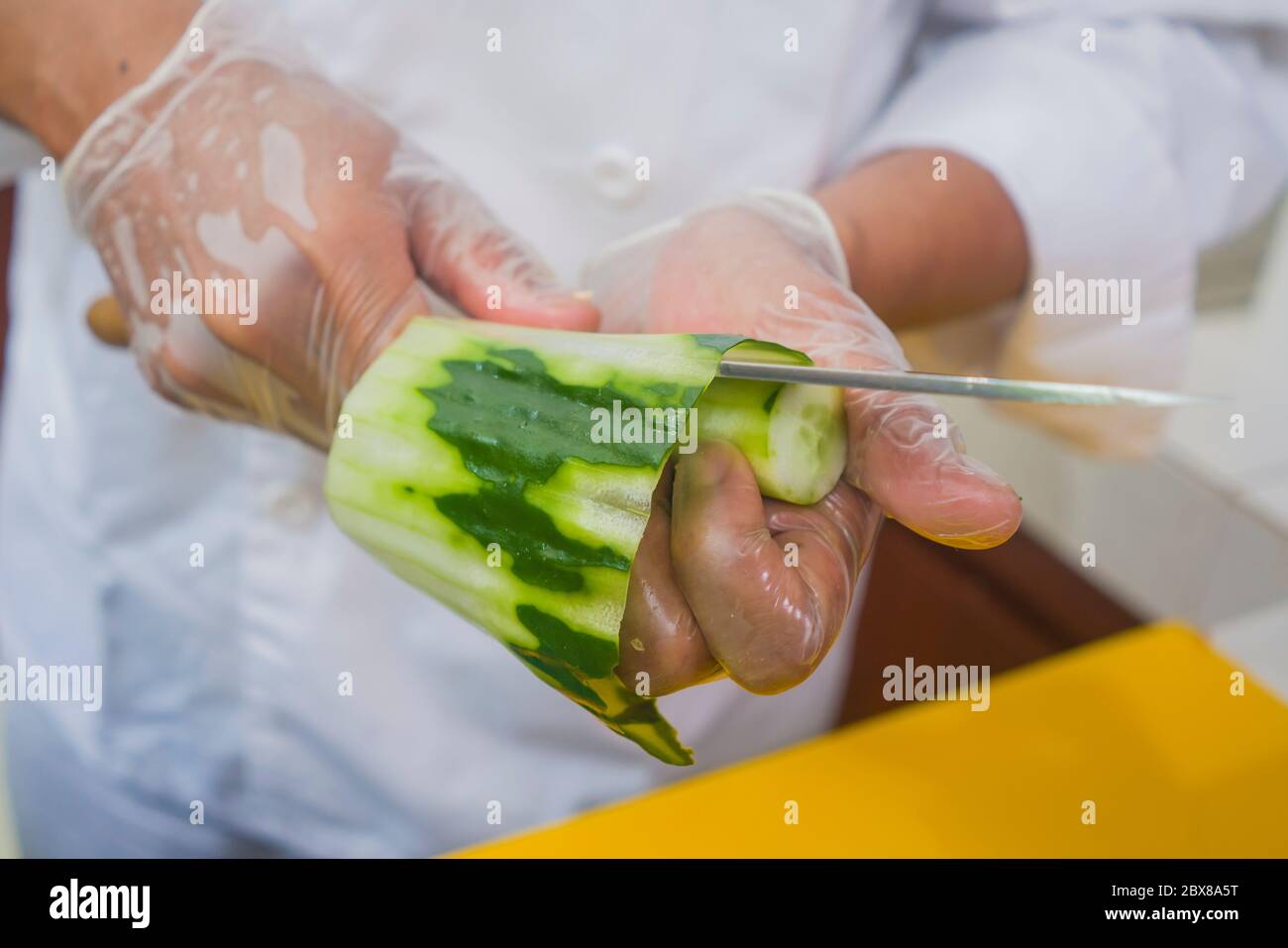 Hände in Handschuhe von asiatischen professionellen Koch Vorbereitung  japanische Sushi-Rollen Schneiden Gurke mit Messer zu Hause oder Restaurant  Küche machen traditionell Stockfotografie - Alamy