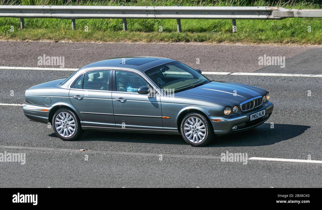 2003 silberglau britischer Jaguar XJ8 V8 SE Auto; Fahrzeuge mit bewegtem Verkehr, Fahrzeuge, die Fahrzeuge auf britischen Straßen fahren, Motoren, Fahrzeuge auf der Autobahn M6 Stockfoto