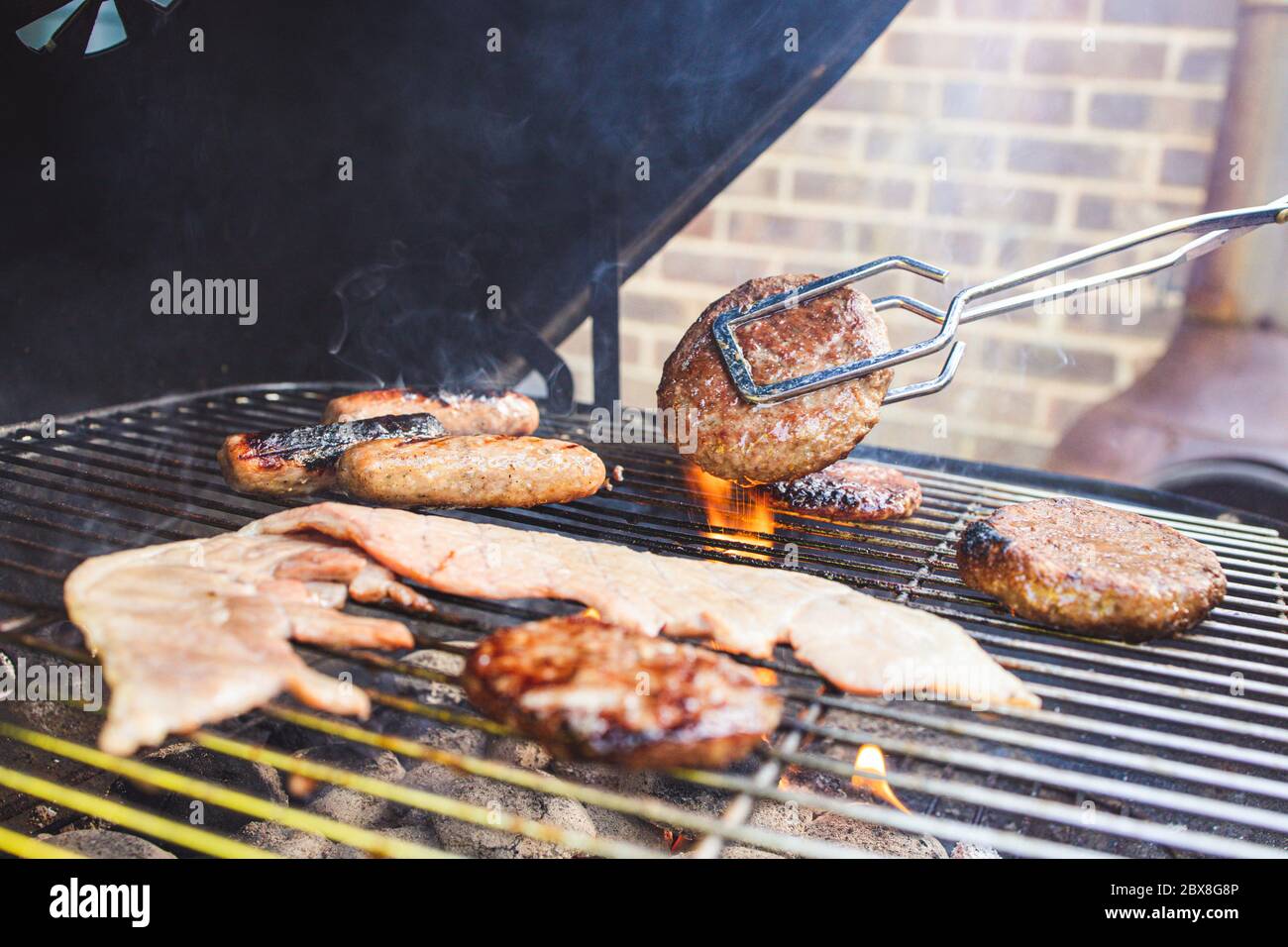 Sommer Zeit im Freien BBQ Kochen Fleisch mit Flammen Stockfoto
