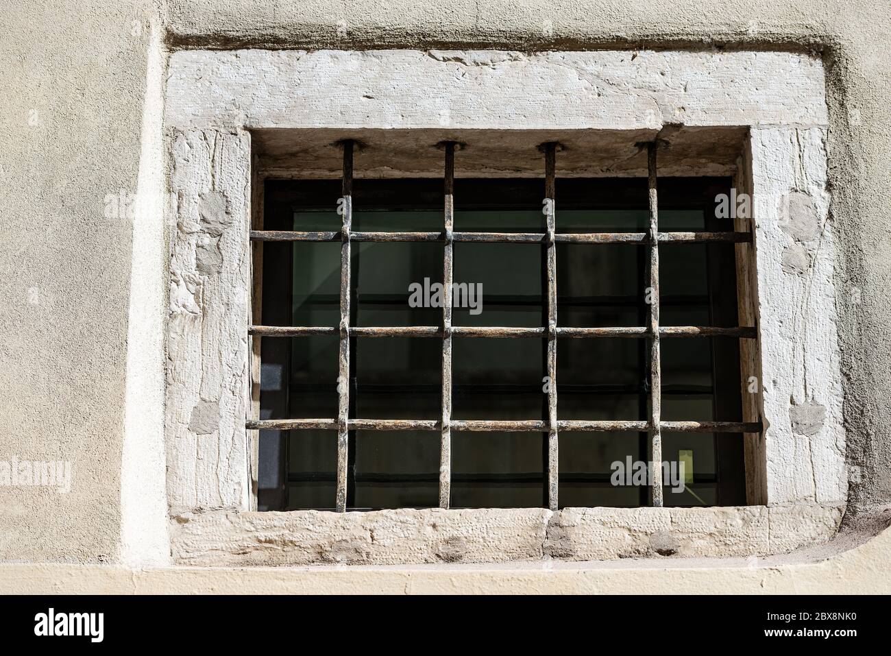 Nahaufnahme eines alten Fensters mit schmiedeeisernen Sicherheitsstangen und Einbruchalarm. Trentino Alto Adige, Italien, Europa Stockfoto