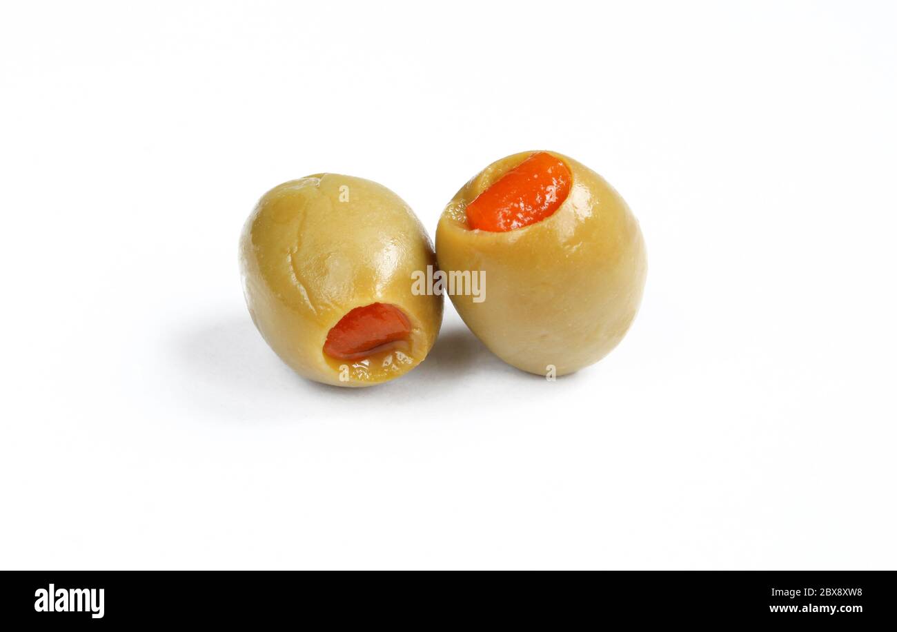 Zwei grüne Oliven gefüllt mit rotem Pfeffer. Nass gefüllte Oliven isoliert Stockfoto