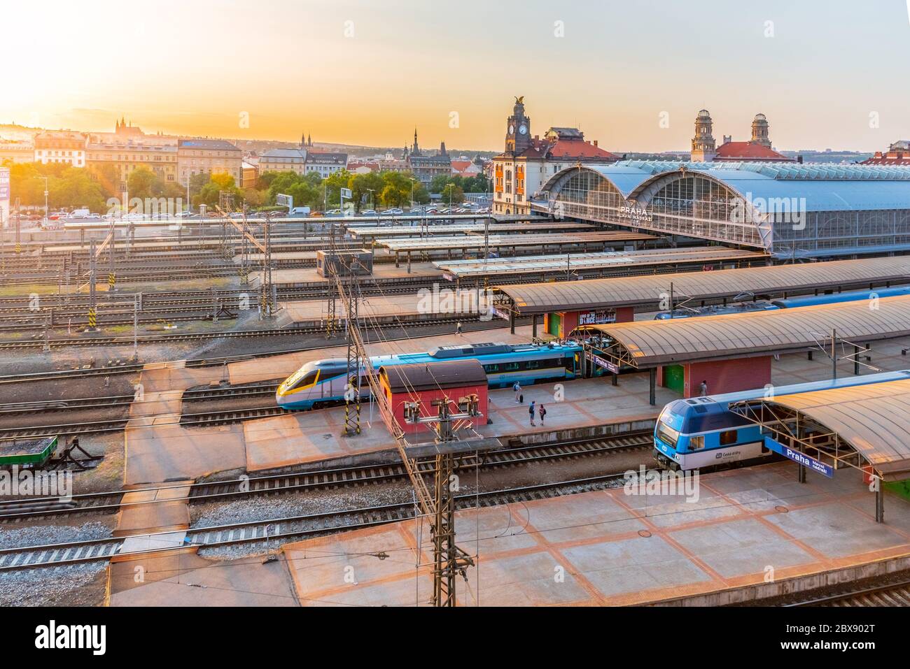 PRAG, TSCHECHISCHE REPUBLIK - 17. AUGUST 2018: Prager Hauptbahnhof, Hlavni nadrazi, mit historischen Gebäuden und Prager Burg im Hintergrund bei Sonnenuntergang. Prag, Tschechische Republik. Stockfoto