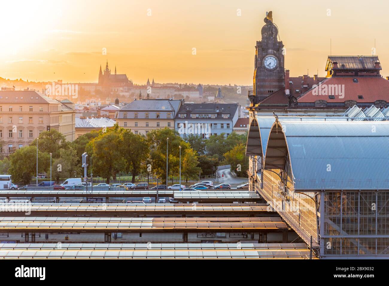 Prager Hauptbahnhof, Hlavni nadrazi, mit historischen Gebäuden und Prager Burg im Hintergrund bei Sonnenuntergang. Prag, Tschechische Republik. Stockfoto