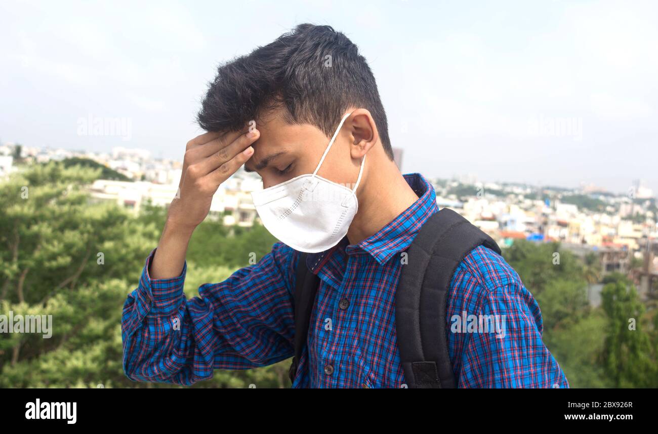 Ein junger männlicher Teenager Student trägt Gesichtsmaske und besorgt über Epidemie Gesundheitskrise. Stockfoto