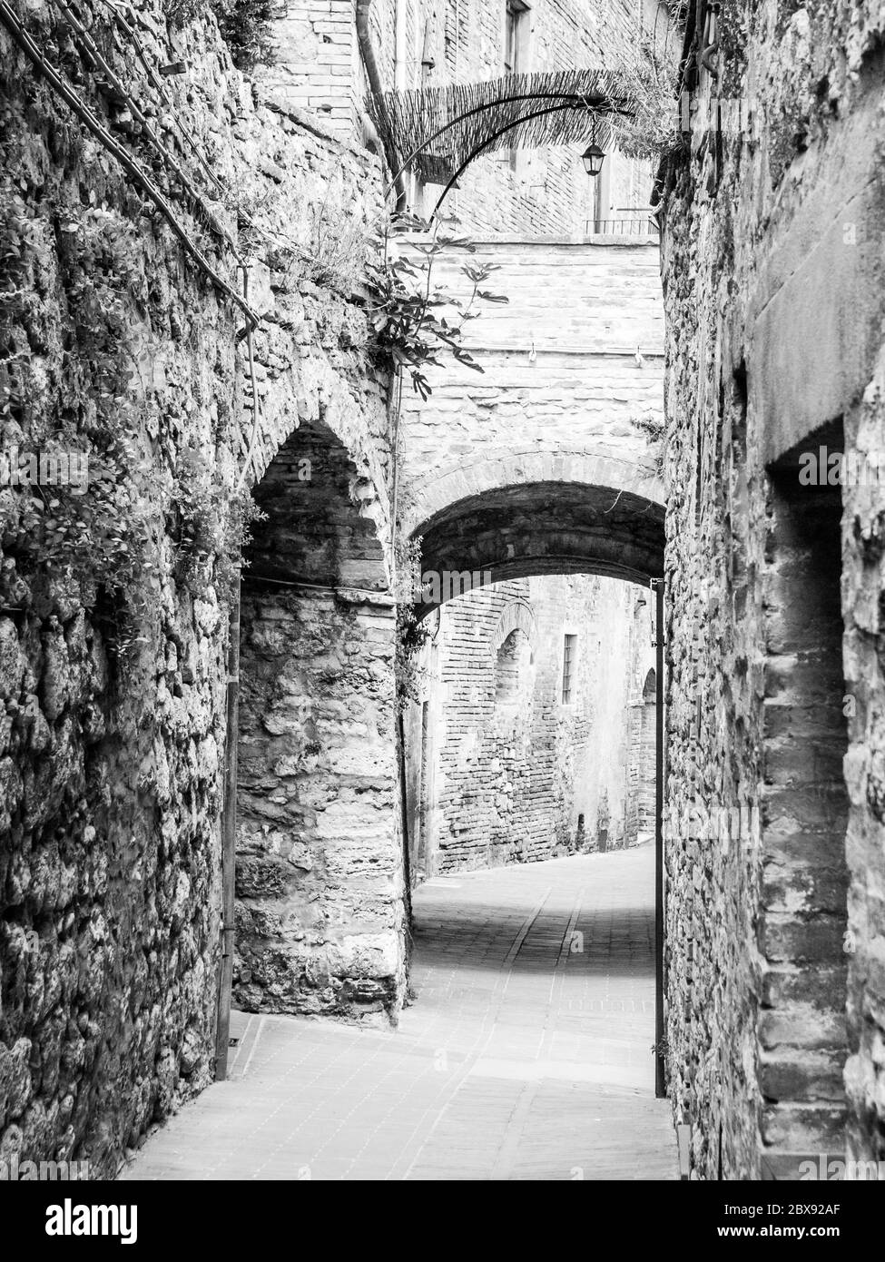 Malerische mittelalterliche schmale Straße von San Gimignano Altstadt, Toskana, Italien. Schwarzweiß-Bild. Stockfoto