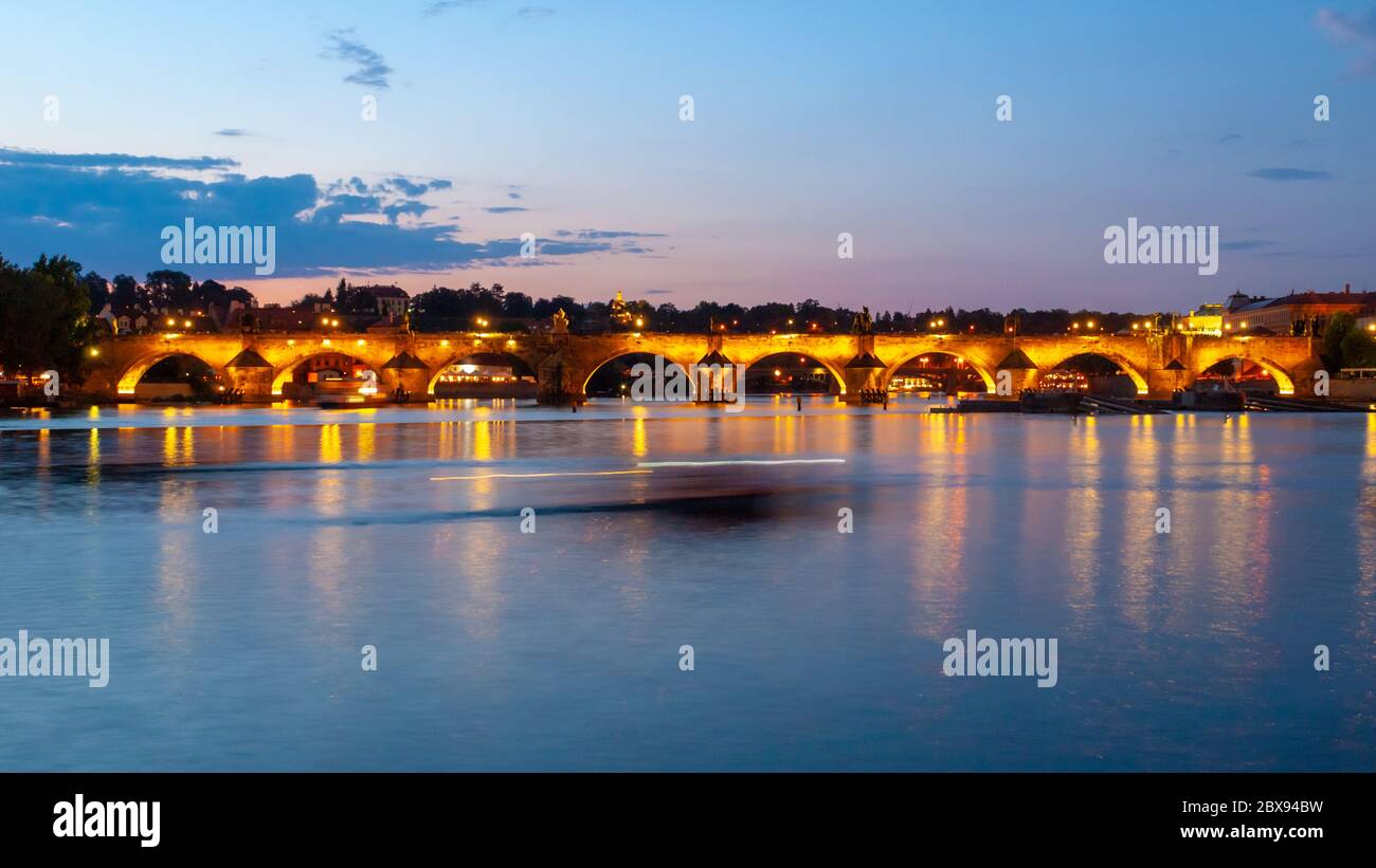 Beleuchtete Karlsbrücke spiegelt sich in der Moldau bei Nacht. Prag, Tschechische Republik. Stockfoto