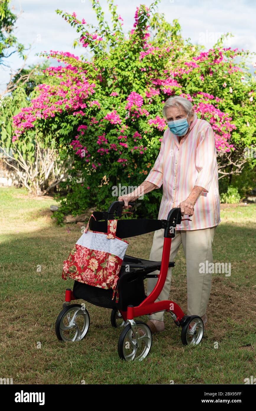 Ältere Dame mit Maske immer Bewegung gehen für einen Spaziergang im Garten Stockfoto