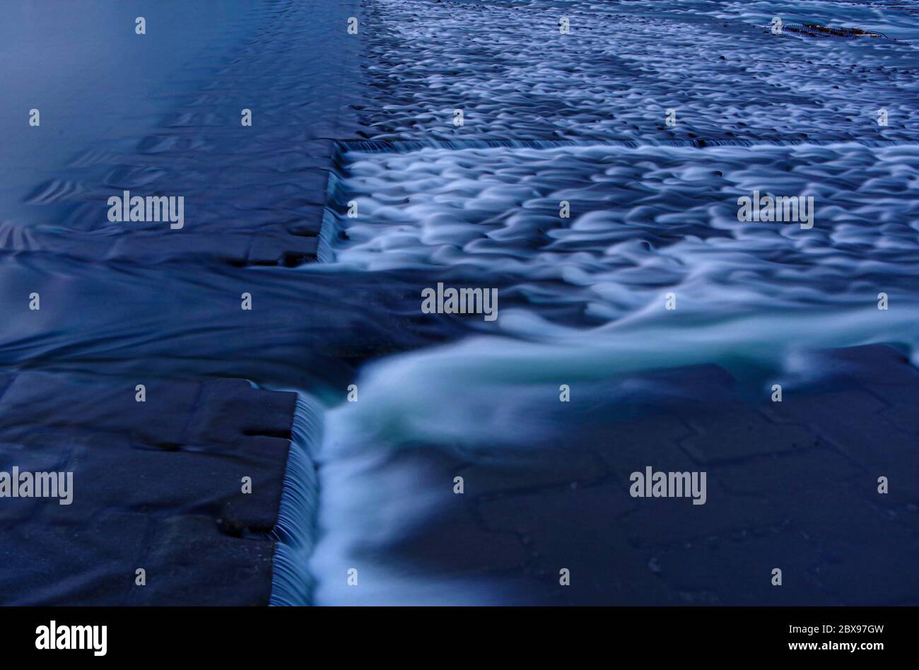 Nicht ganz sicher, was der Zweck dieser Art von Wehranlage ist. Soll der Wasserfluss verlangsamt werden? Soll es eine Möglichkeit für Fische bieten, stromaufwärts zu schwimmen? Aber ich bin ja Stockfoto