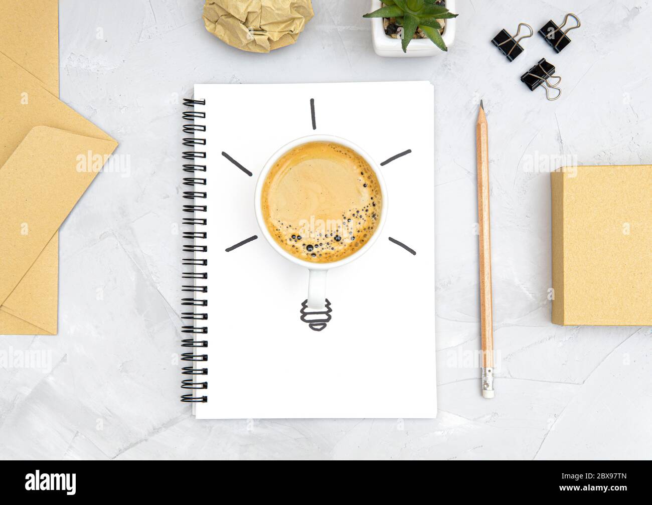 Glühbirne Symbol aus einer frischen Tasse Kaffee und eine Skizze auf einem Spiralnotizbuch. Büro Arbeitsplatz flach legen. Erfrischungs- und Produktivitätskonzept. Bo Stockfoto