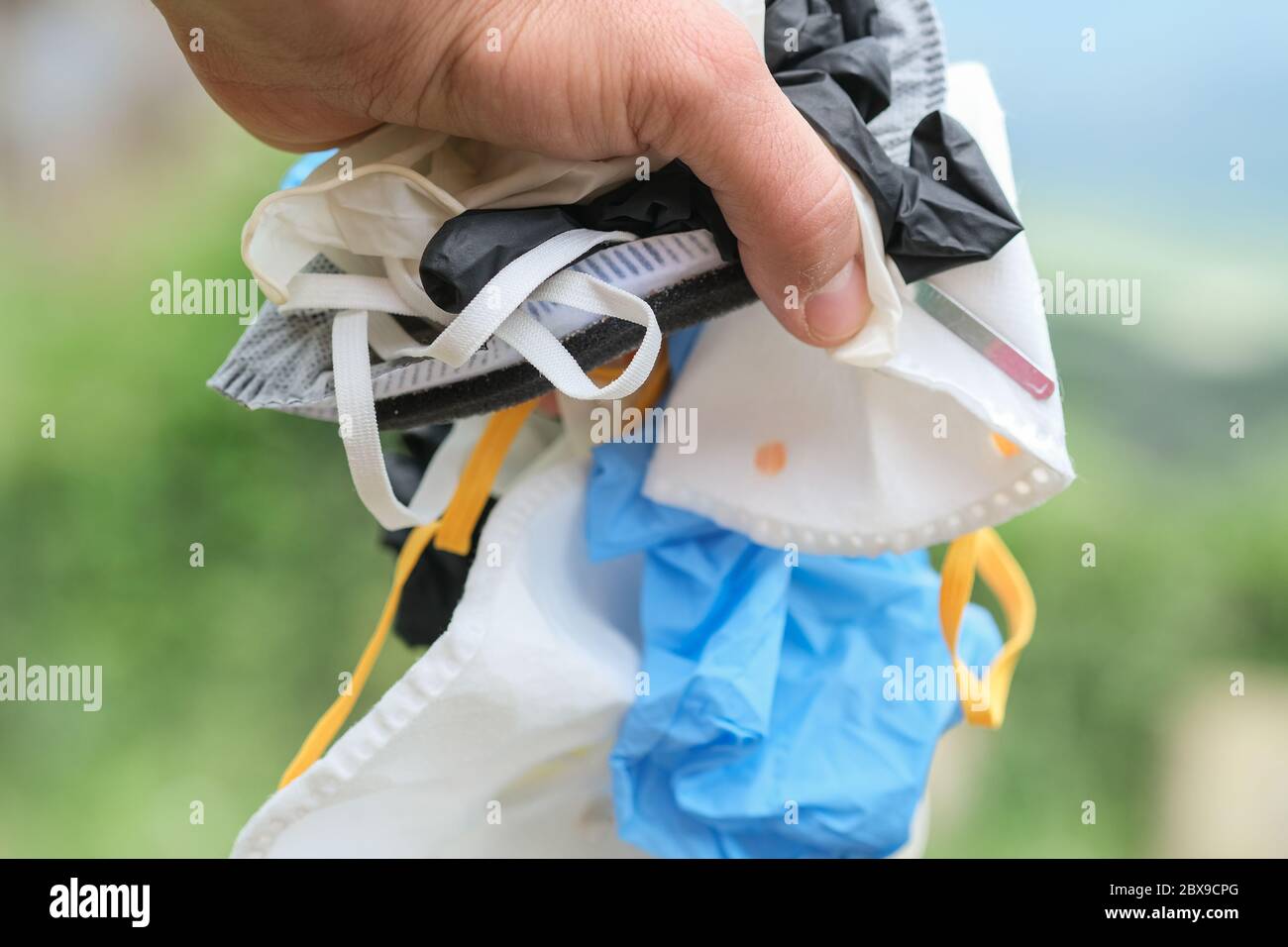 Menschliche Hand mit Medical schmutzige Abfallmaske und Handschuhe Müll, Coronavirus Krankheit Ausrüstung Stockfoto