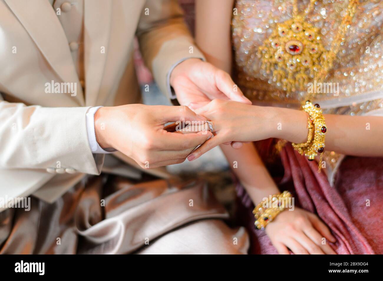 Braut und Bräutigam setzen Ehering auf Finger, Thai Hochzeit Verlobungszeremonie Stockfoto