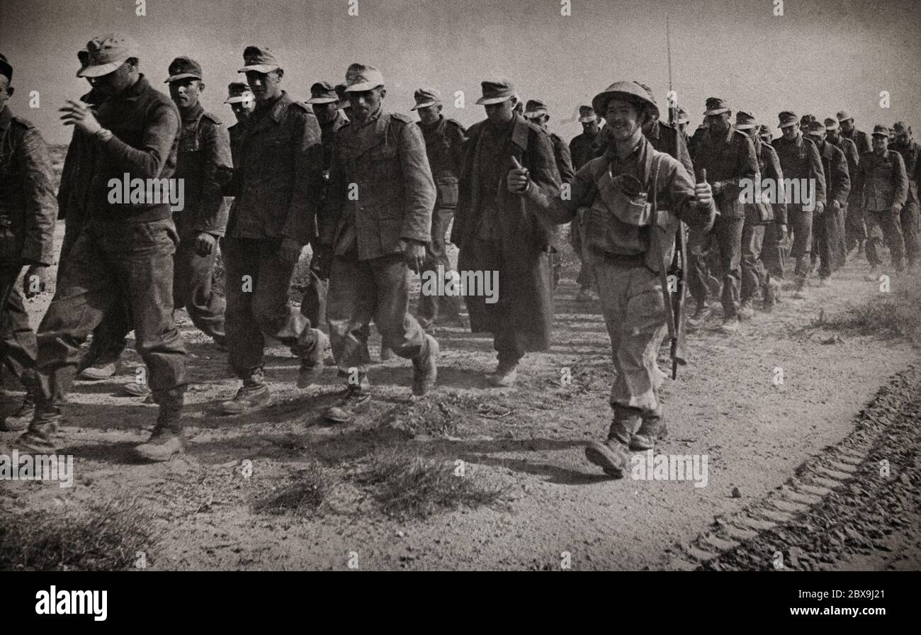 Daumen hoch von einem britischen Soldaten, der einige der Tausenden deutschen Gefangenen nach dem Sieg der Alliierten in El Alamein in Ägypten während der Westwüstenkampagne begleitet. Stockfoto