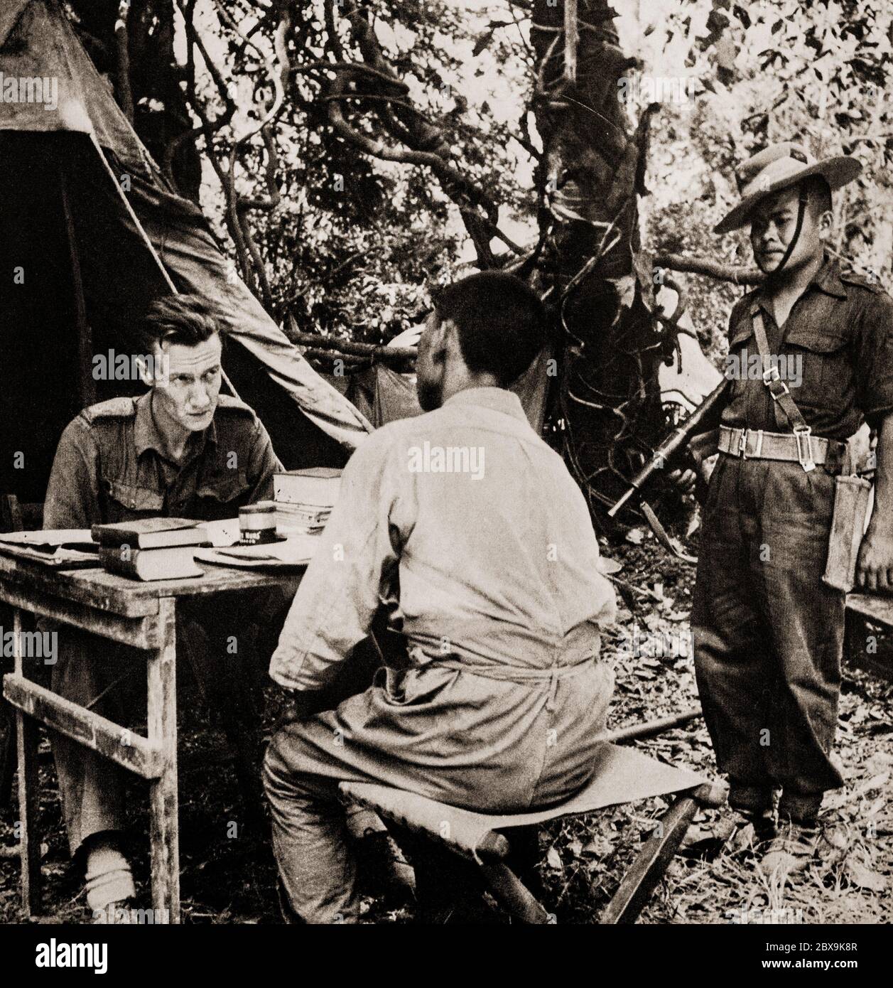 Ein britischer Offizier der Gurkha-Einheit verhört einen japanischen Gefangenen während der Schlacht von Imphal in der Region um die Stadt Imphal, der Hauptstadt des Staates Manipur im Nordosten Indiens von März bis Juli 1944. Japanische Armeen versuchten, die alliierten Truppen in Imphal zu zerstören und in Indien einzufallen, wurden aber mit schweren Verlusten nach Burma zurückgefahren. Stockfoto
