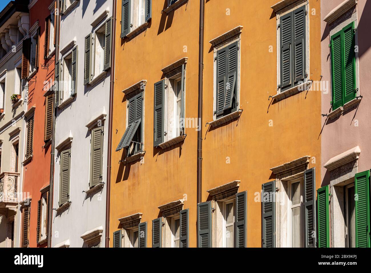 Fassade von generischen Häusern mit vielen Fenstern und Fensterläden in einer Straße in Trentino-Südtirol, Italien, Europa Stockfoto